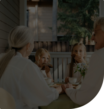 A couple sitting at a table across from two young children.